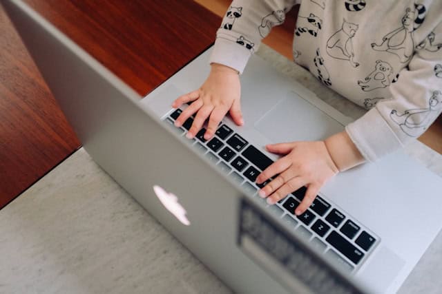 Photograph of baby on laptop to illustrate the family-friendly nature of peer consultation sessions