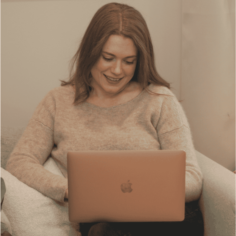 Photo of psychologist Natalie Stokes, in office working on laptop